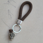 Preview: Schlüsselanhänger mit zwei Tannenzapfen und brauner Paracord-Schlaufe