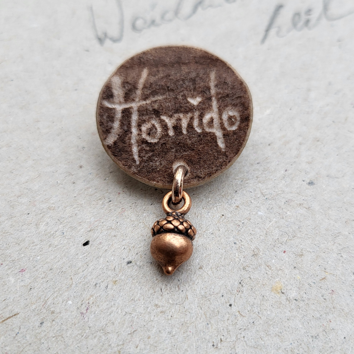 Preview: Handgefertigte Jagdbrosche aus Hirschhorn mit Horrido Schriftzug im Detail und bronzefarbenem Eichel Anhänger