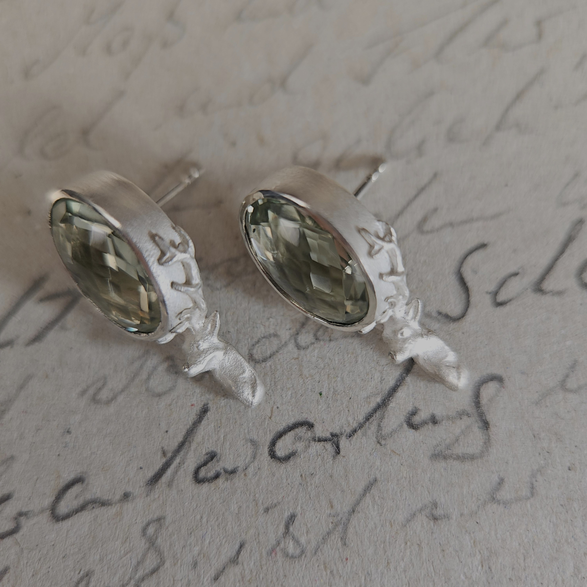 Ohrstecker mit ovalem Prasiolith und Hirschmotiv aus 925 Silber in schräger Ansicht