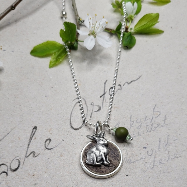 Kette mit rundem Hornanhänger und Hase und grünen Perlen