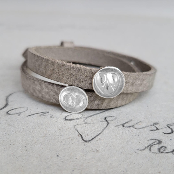 Armband doppelt mit zwei Symbolplaketten "beziehungsweise"